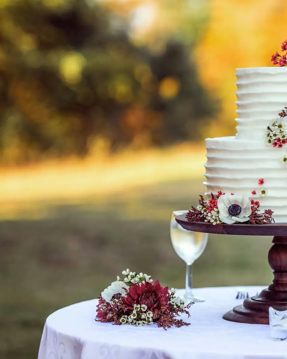 Torta de bodas blanca con flores sobre una mesa en el jardín