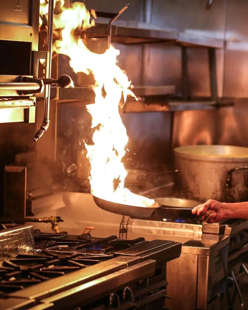 El parrillero de Fuego Manso trabajando frente a las llamas en la cocina
