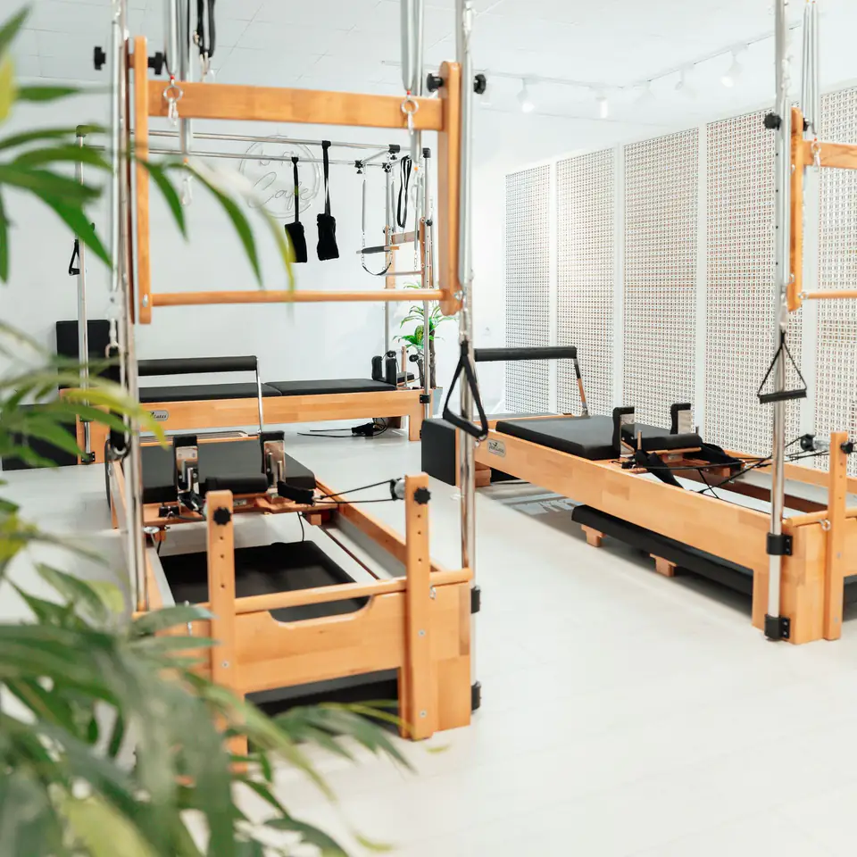 Estudio luminoso con plantas y equipos de pilates